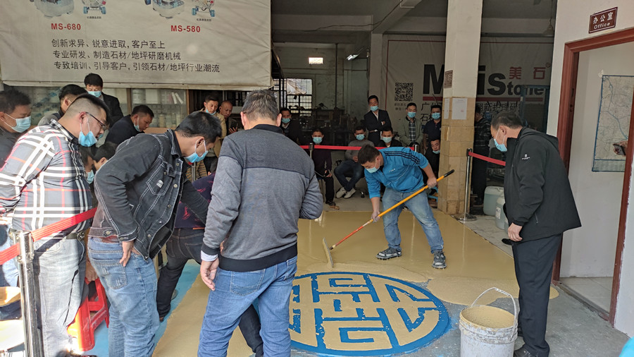 澳恒工作人员示范摊铺过程